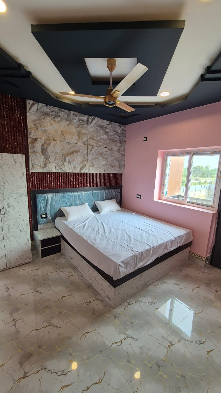 Standard Room with pink walls and a window overlooking the highway