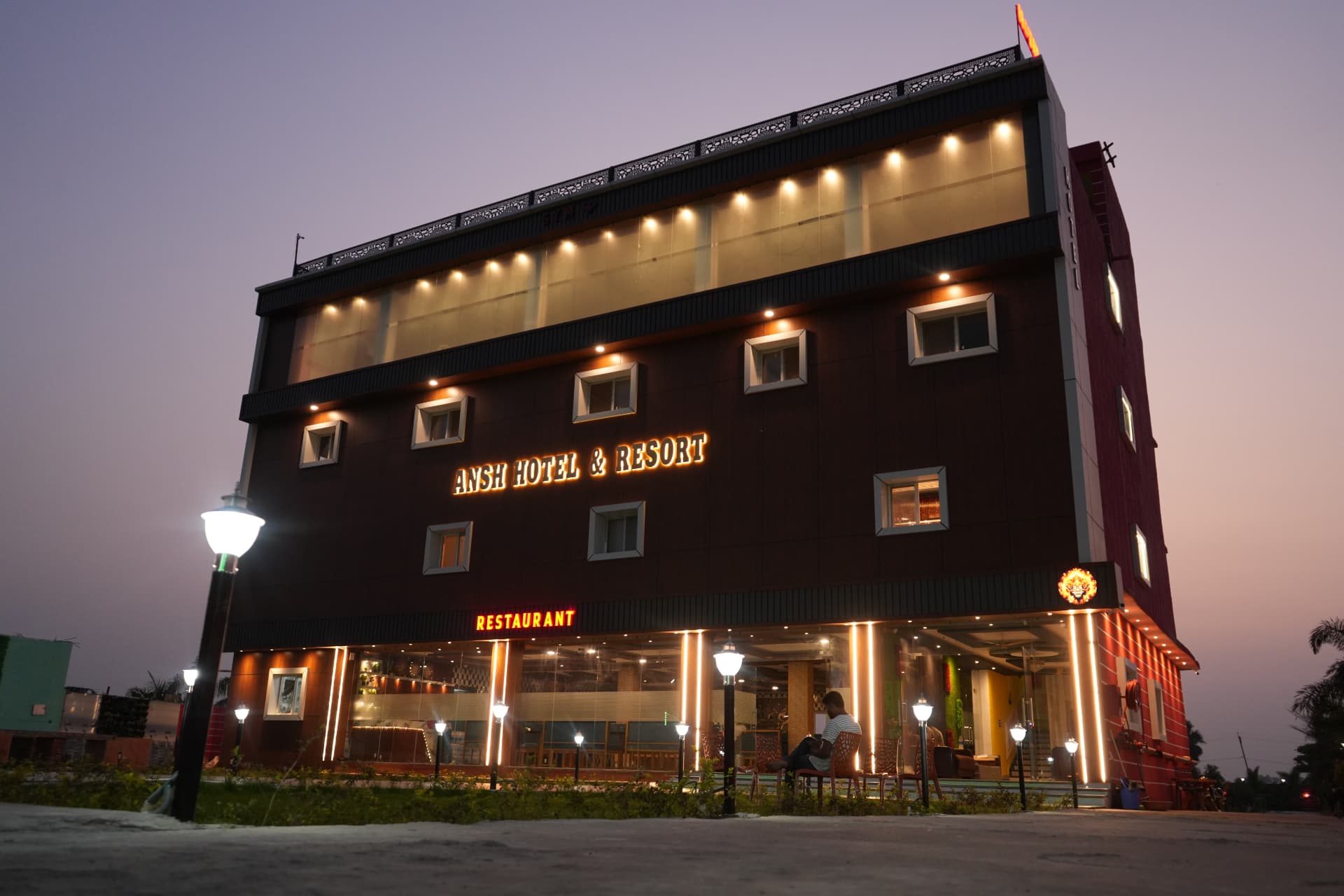 Ansh Hotel & Resort facade lit up at night